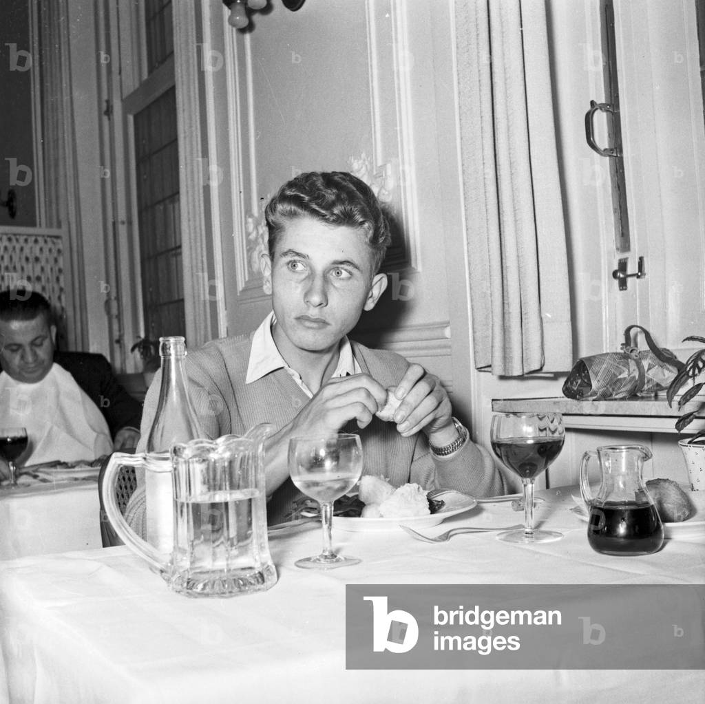 Cyclist Jacques Anquetil at the restaurant after the victory of the Grand Prix of Lugano (1953) (b/w photo)