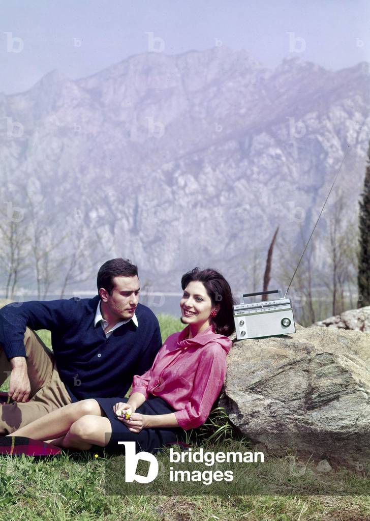 A couple listening to the radio at a mountain picnic, 1960s (photo)