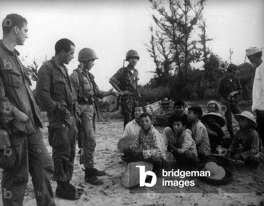 US Marines and South Vietnamese soldiers guarding Vietcong prisoners, Saigon, 1967 (b/w photo)