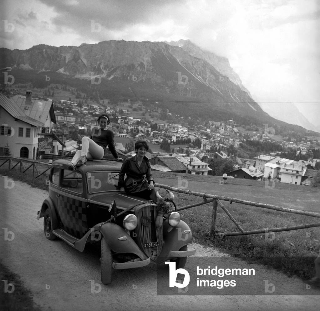 Holidaymakers posing on an old Fiat 508 Balilla car, Cortina d'Ampezzo, Italy, 1959 (b/w photo)