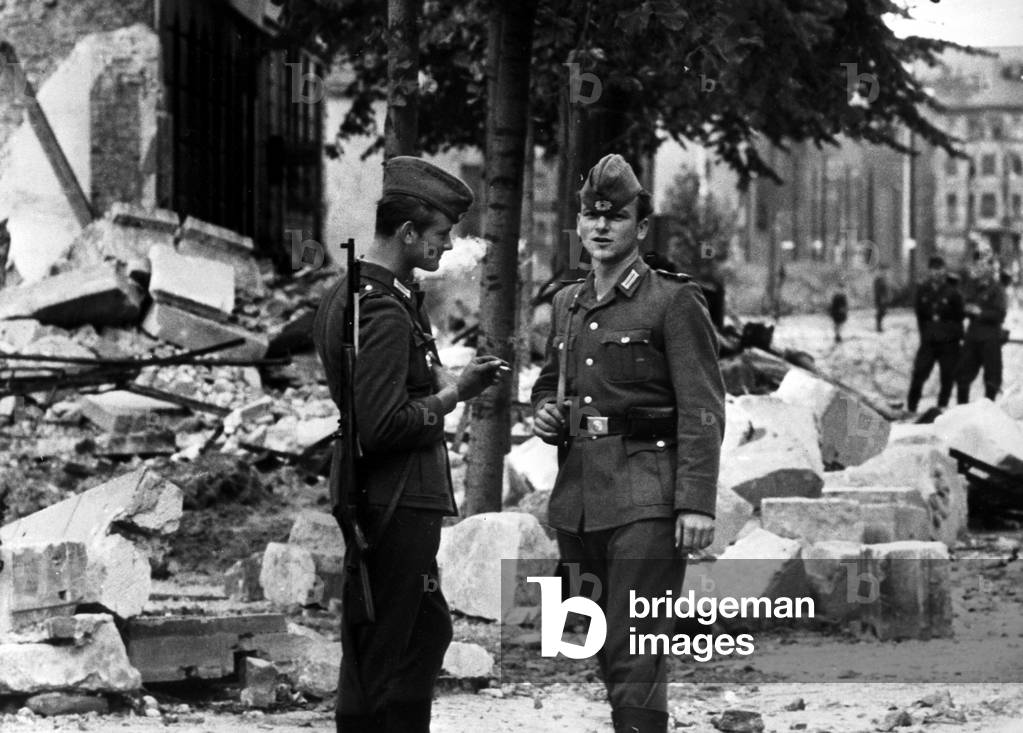 Two soldiers of the East German National People's Army on guard at the border wall in Zimmerstrasse, Berlin, 1961 (b/w photo)