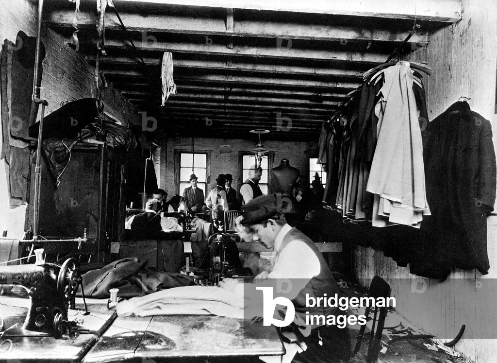 A young worker in a tailor shop, New York, USA, 1912 (b/w photo)