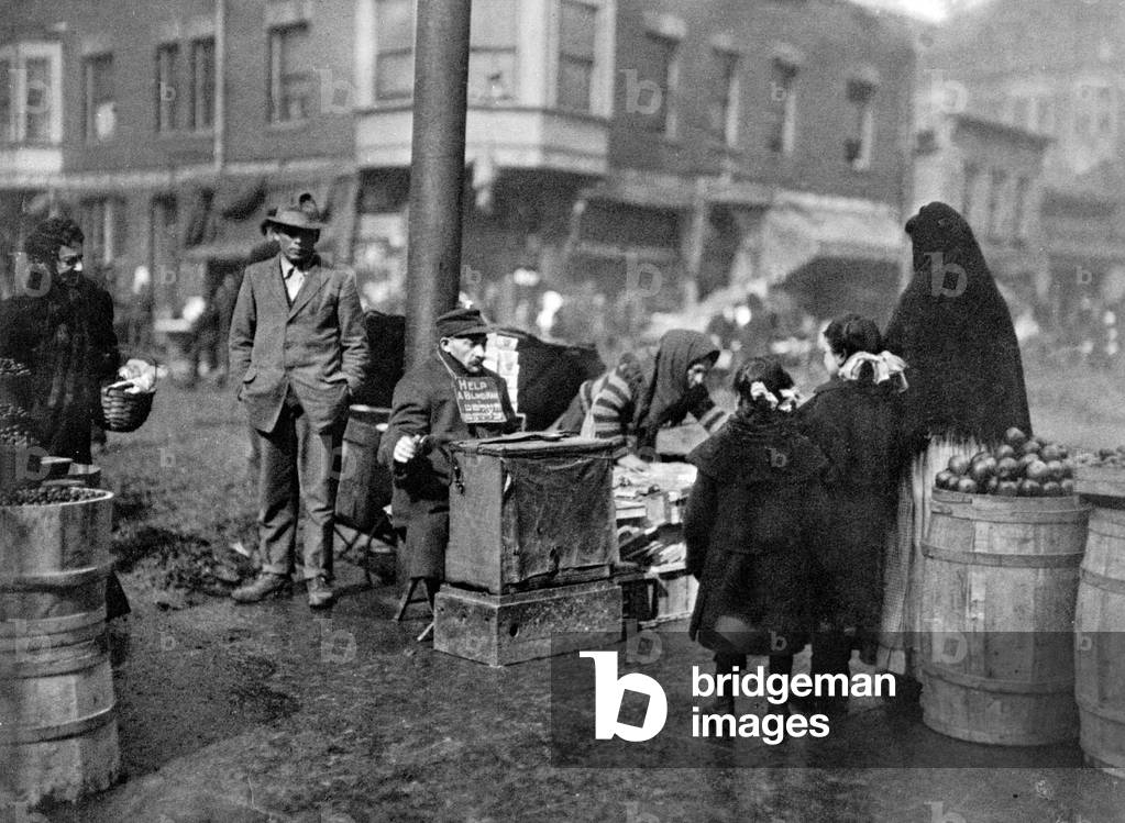 A blind beggar collecting in the Italian Quarter, Chicago, USA, 1911 (b/w photo)