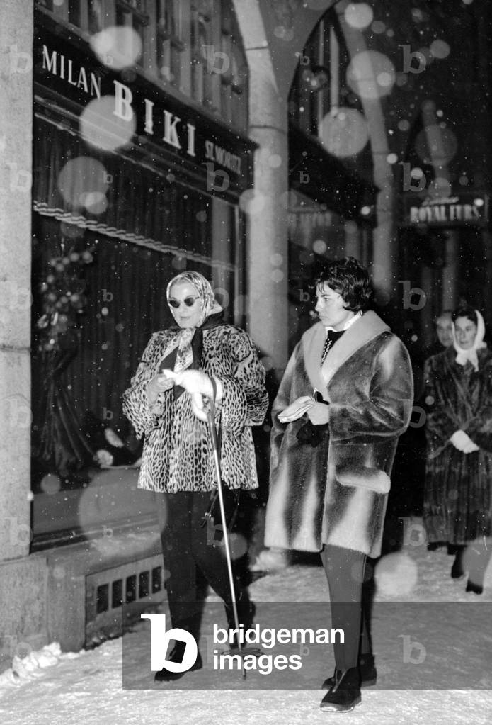 Princess Soraya Esfandiary-Bakhtiary walking through the streets of the ski resort with her mother, Saint Moritz, 1958 (b/w photo)
