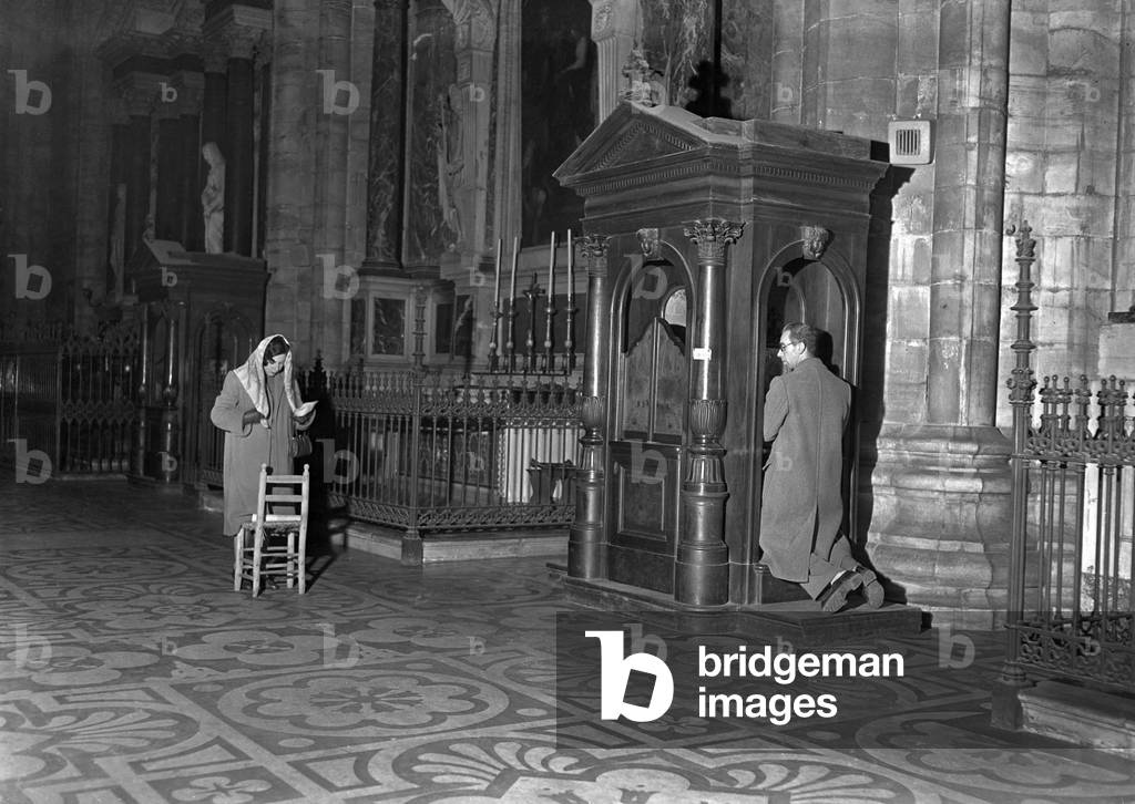 Milan, 11/1950. La Cathedrale de Milan (Duomo), confession des fideles. 