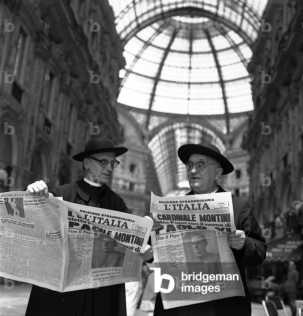 Two priests reading the dailies announcing the election of the new Pope Paul VI in the Vittorio Emanuele II gallery, Milan, 1963 (b/w photo)