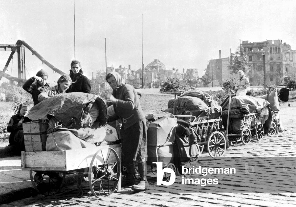 Berliners, returning home pushing carts through the ruins, Berlin, Germany, 1945 (b/w photo)