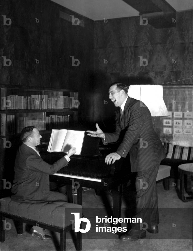 Primo Carnera singing with the pianist aboard the transatlantic ship Conte di Savoia returning from the United States, 1933 (b/w photo)