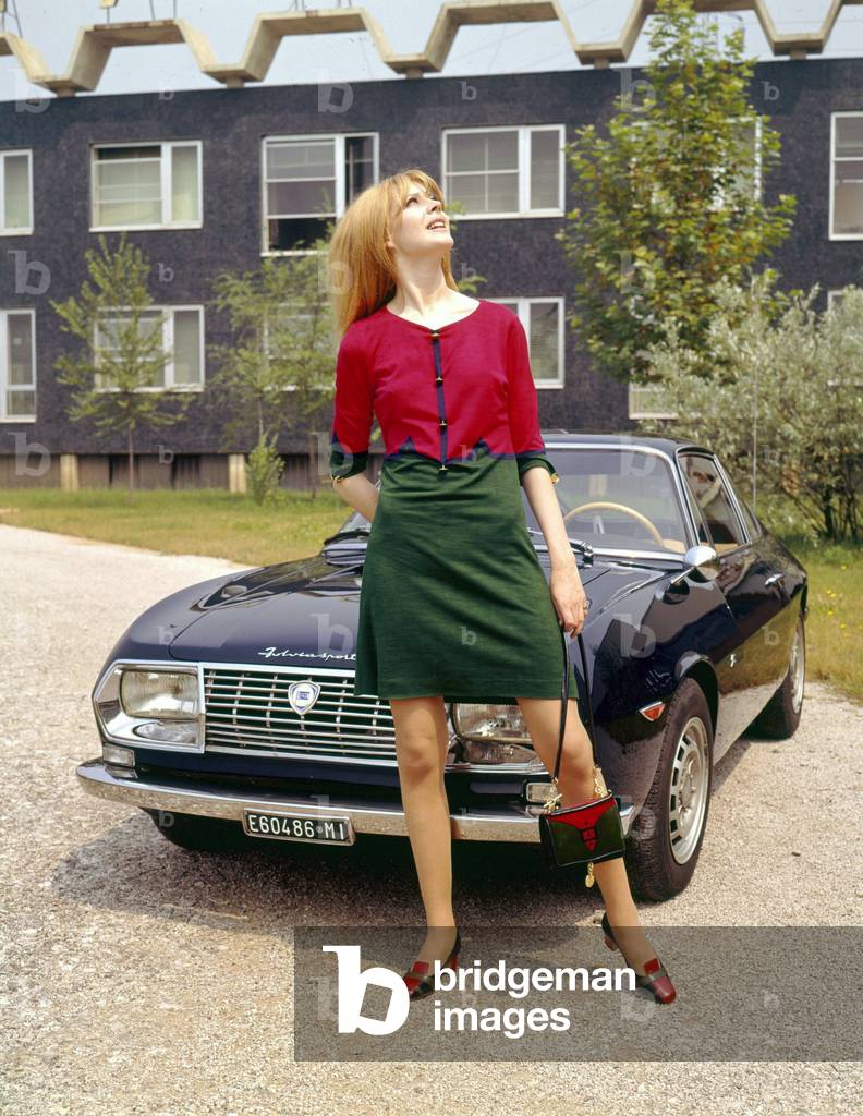 A model posing in front of a Lancia Fulvia sport 1.3 Zagato, 1963 (photo)