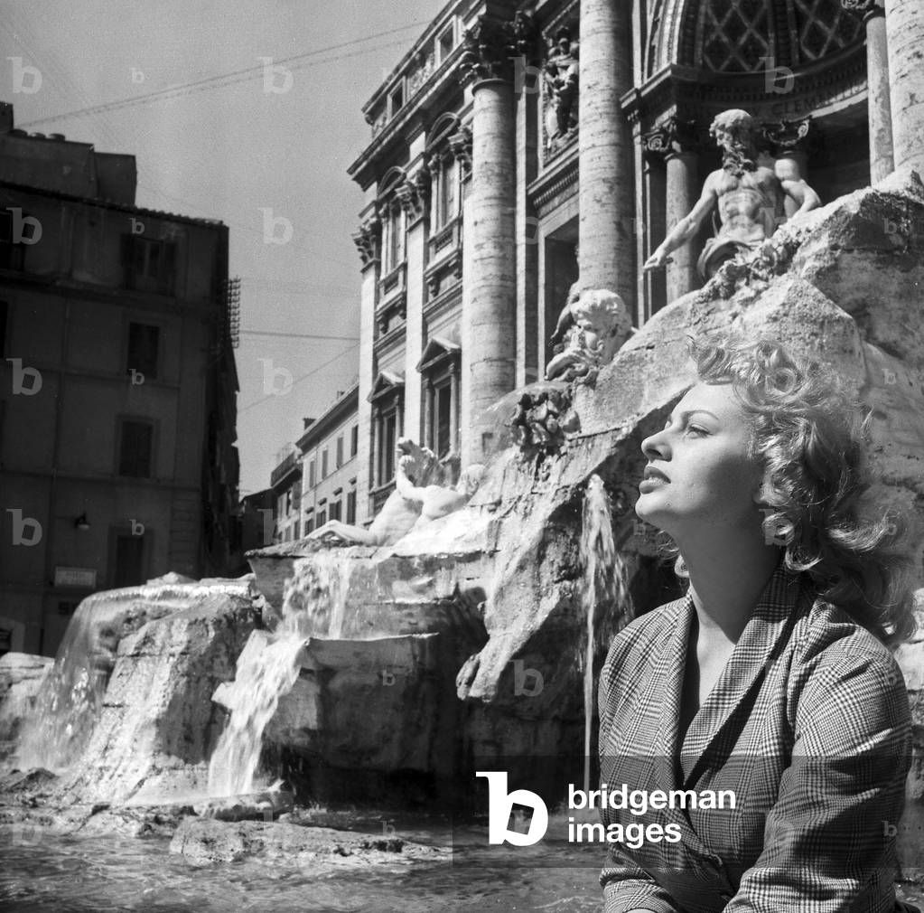 Sophia Loren sitting by the fountain of Trevi, Rome, 1954 (b/w photo)