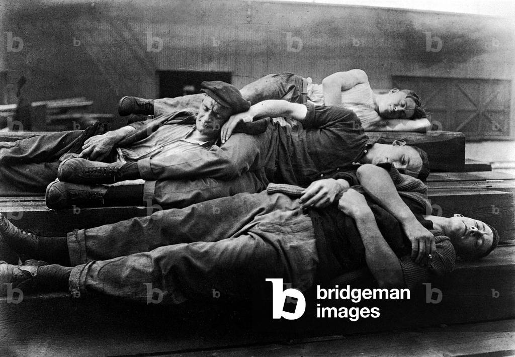 Dockworkers taking a nap in the harbour, New York, USA, 1922 (b/w photo)