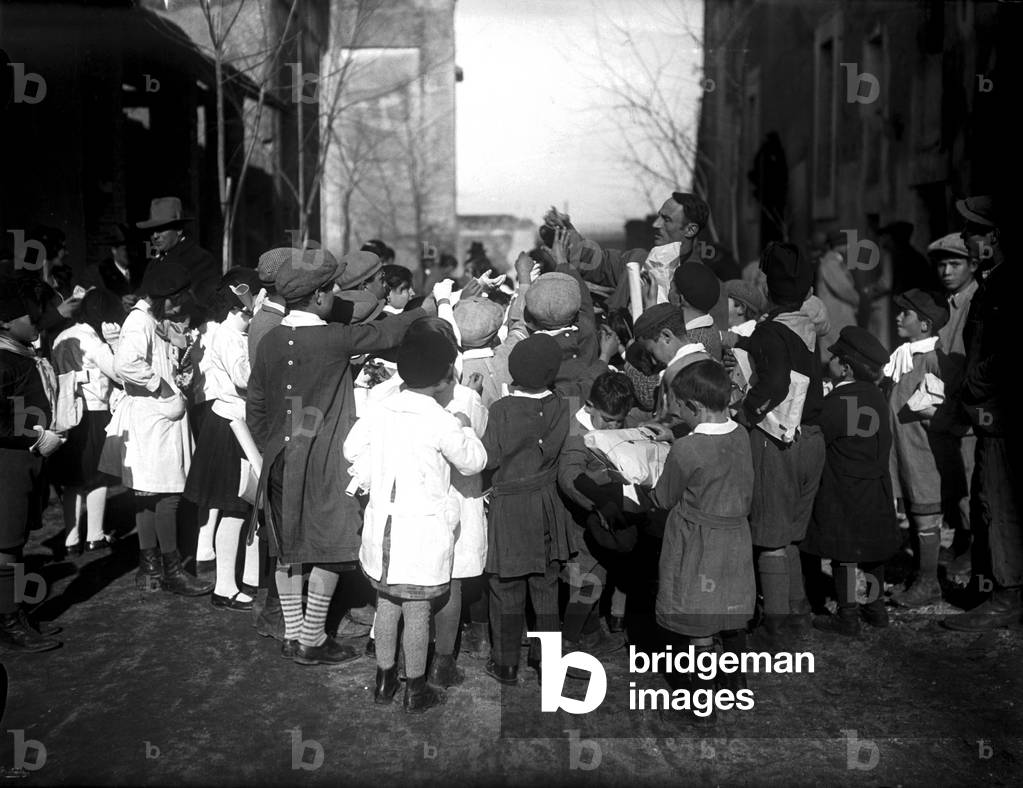 The Fascist social institution 'Befana Fascista' distribute gifts to children in the area, Rome 22/01/1933 (b/w photo)