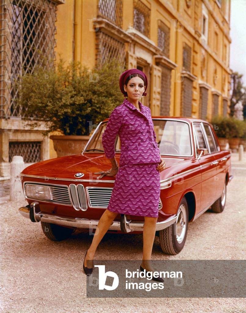 Model posing in front of a BMW 2000 sedan, 1966 (photo)