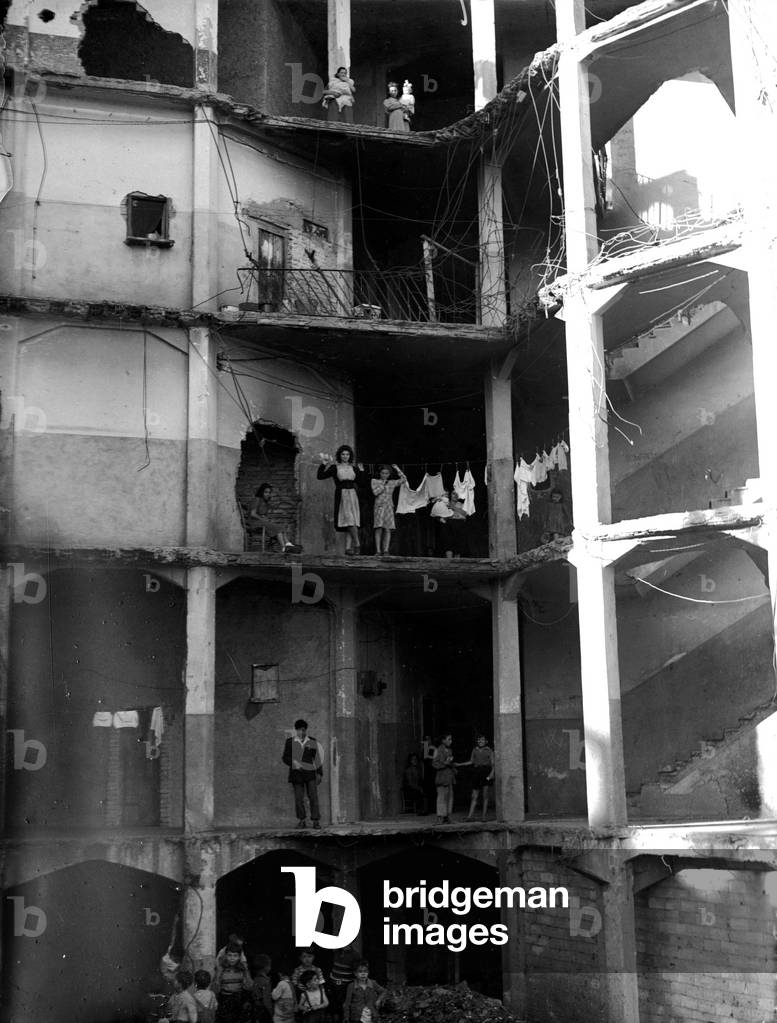Inhabitants of a house in ruins because of the bombings, Rome, 1949 (b/w photo)