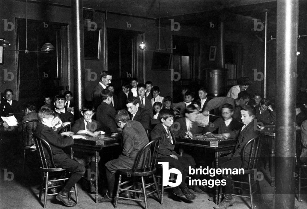 Young immigrants in a club recreation room, Boston, USA, 1909 (b/w photo)