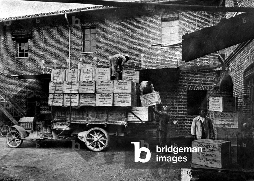 Genes, 1920. Les dockers du port dechargent des caisses de materiel Olivetti destinées à partir pour Alexandrie (Egypte). © Farabola/ Leemage