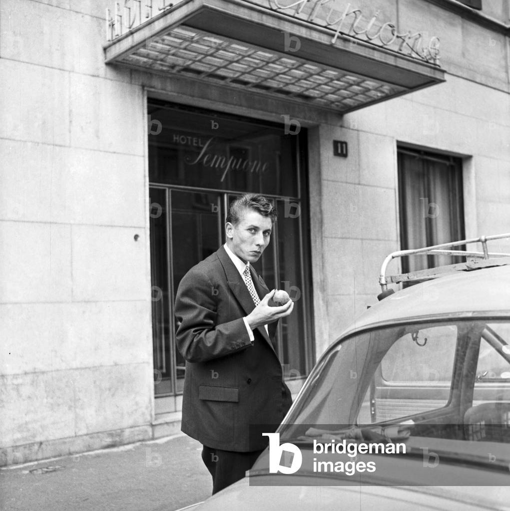 Cyclist Jacques Anquetil (who is in Milan to sign the contract with Bianchi team) outside Sempione Hotel (1955) (b/w photo)