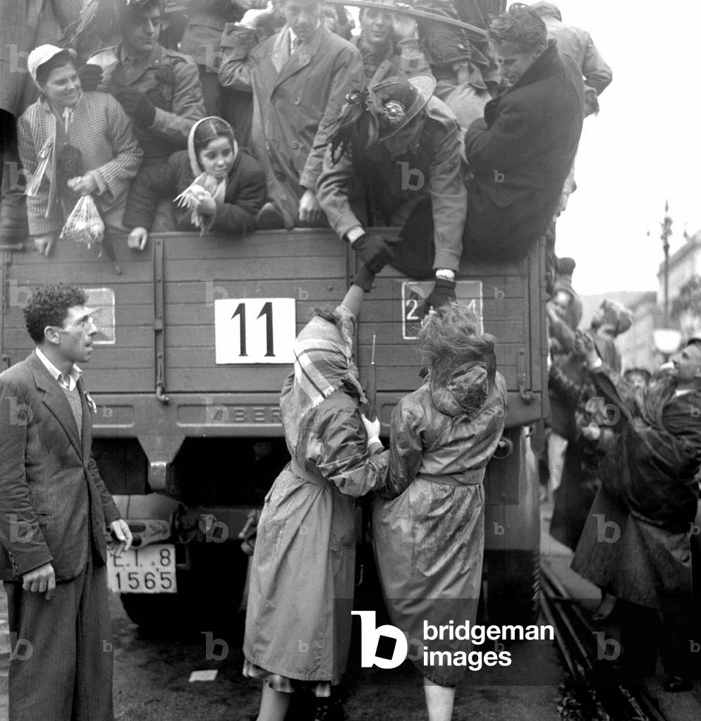 Trieste, 1954. Les troupes italiennes sont entrés dans la ville parmi la foule en liesse. Le 4/11/1954, des jeunes femmes saluent chaleureusement les bersagliers (bersaglieri) qui rendent Trieste à l'Italie.