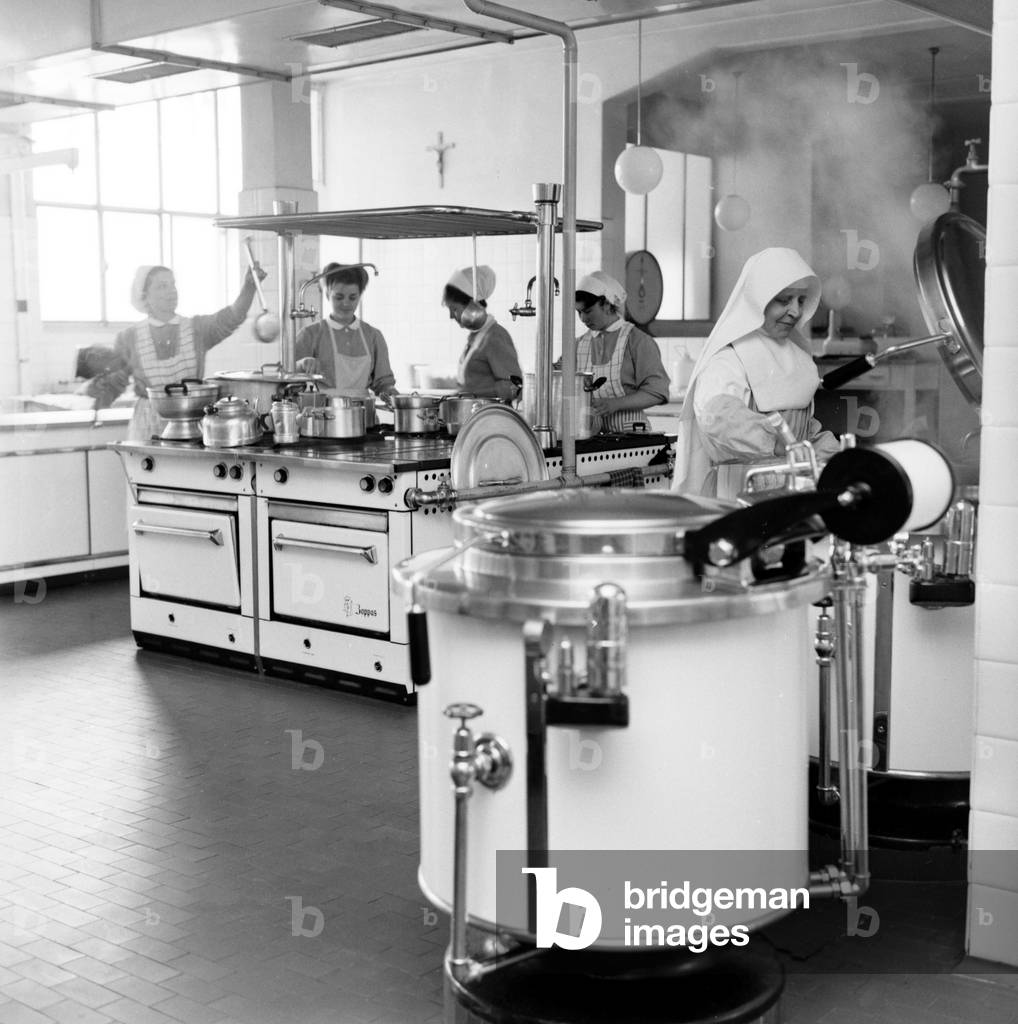 Cooks in the kitchen of a canteen at the Centro St. Maria Nascente clinic, Milan, Italy, 1963 (b/w photo)
