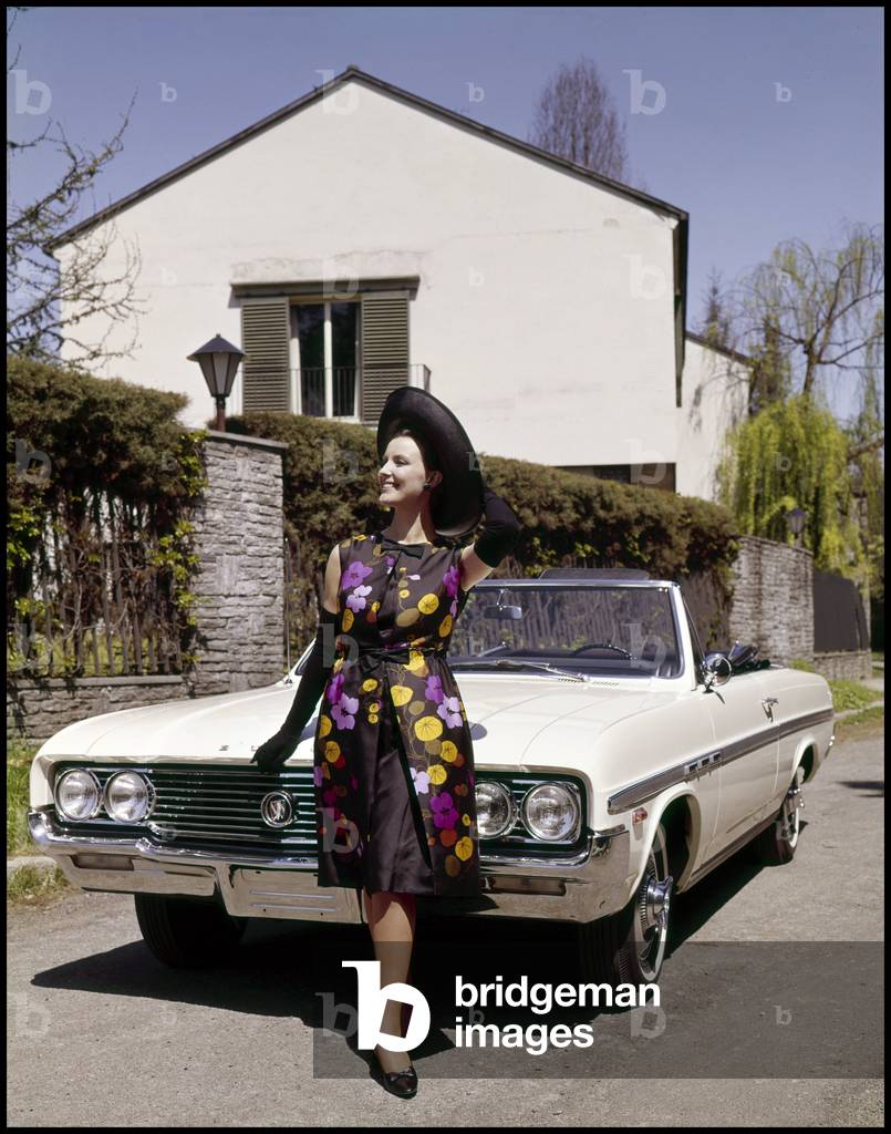 Model posing on a Buick Cabriolet, 1964 (photo)