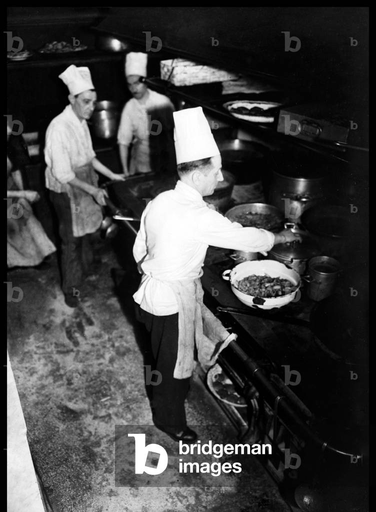 Chefs wearing toques in a restaurant kitchen, 1950s (b/w photo)