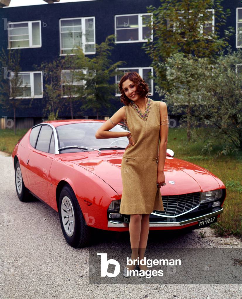 A model posing in front of a Lancia Flavia Zagato, 1963 (photo)