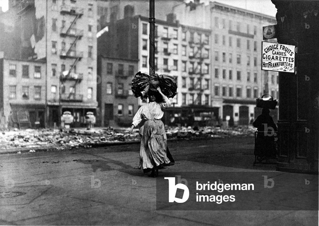 Italian immigrant carrying clothes over her head, New York East Side, USA, 1910 (b/w photo)