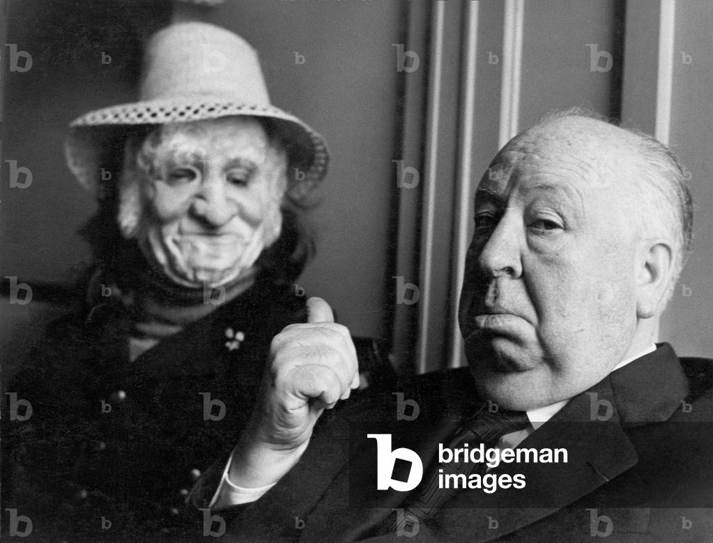 Alfred Hitchcock at the film library, pointing to an automaton, Milan, 1972 (b/w photo)