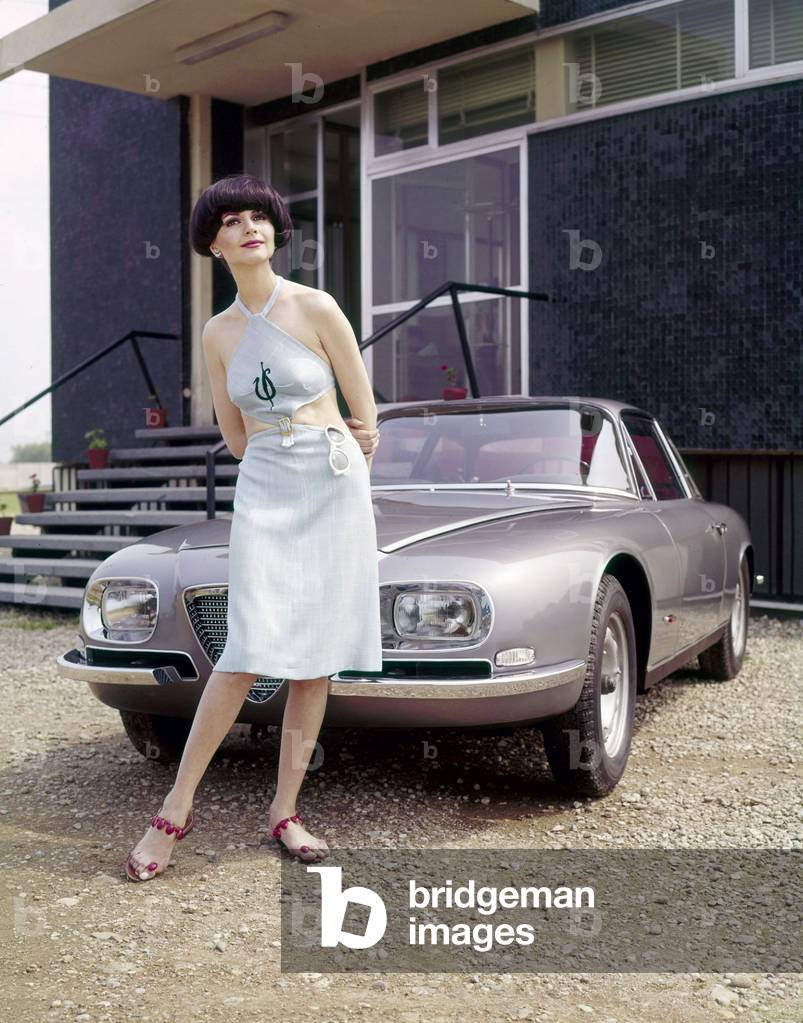 A model posing in front of an Alfa Romeo 2600 SZ Zagato, 1965 (photo)