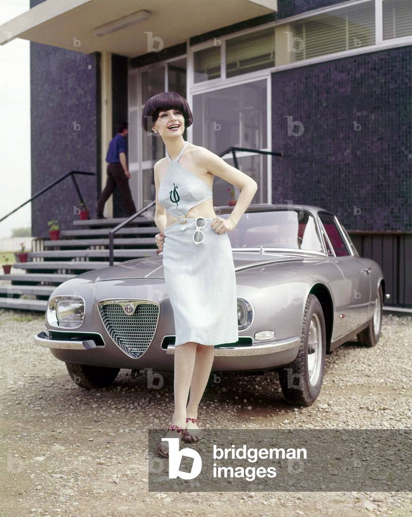 A model posing in front of an Alfa Romeo 2600 SZ Zagato, 1965 (photo)