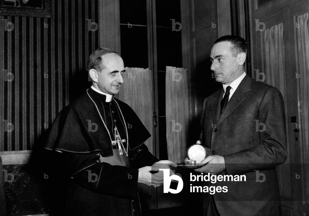 Enrico Mattei presents Monsignor Montini with a miniature model of the church of Santa Barbara in Metanopoli, Milan, 1955 (b/w photo)