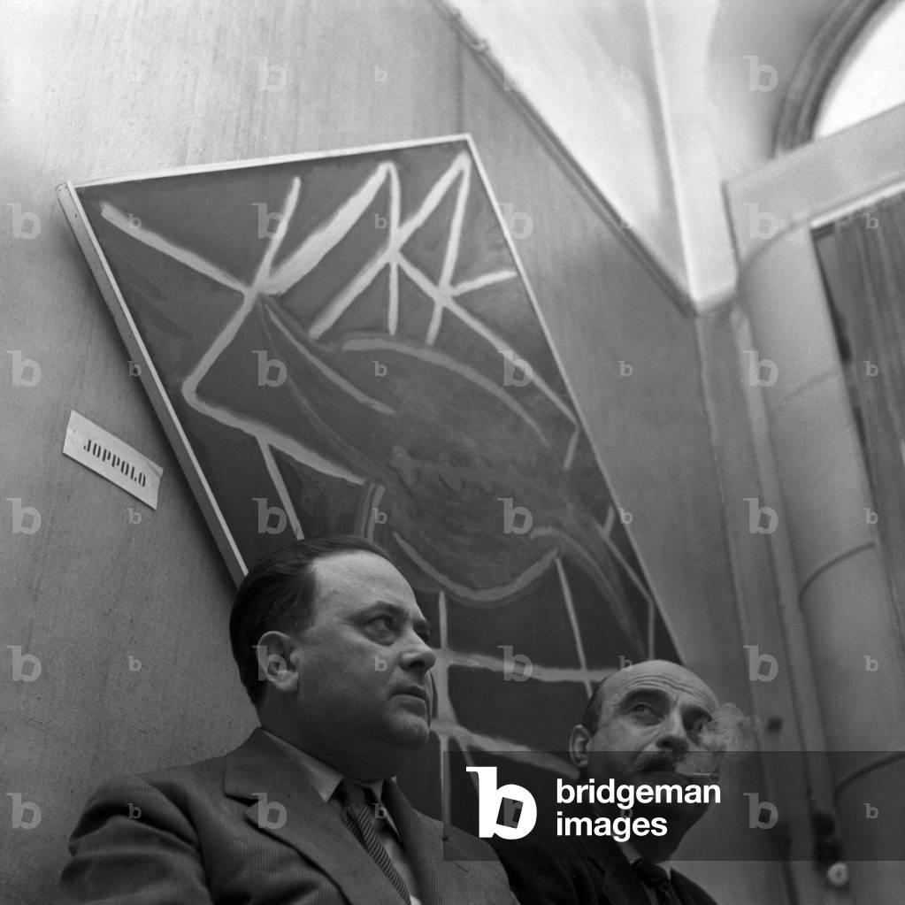 Beniamino Joppolo, with one of his works, and Lucio Fontana at the Arte Spaziale Exhibition at Galleria del Naviglio, Milan, 1952 (b/w photo)