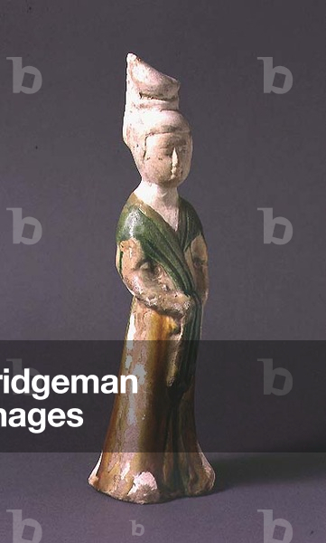 1978-88 Tomb figure of a standing lady with an elaborate coiffeur, green and ochre glazed buff earthenware pottery, Chinese, T'ang dynasty, 7th-early 8th century AD