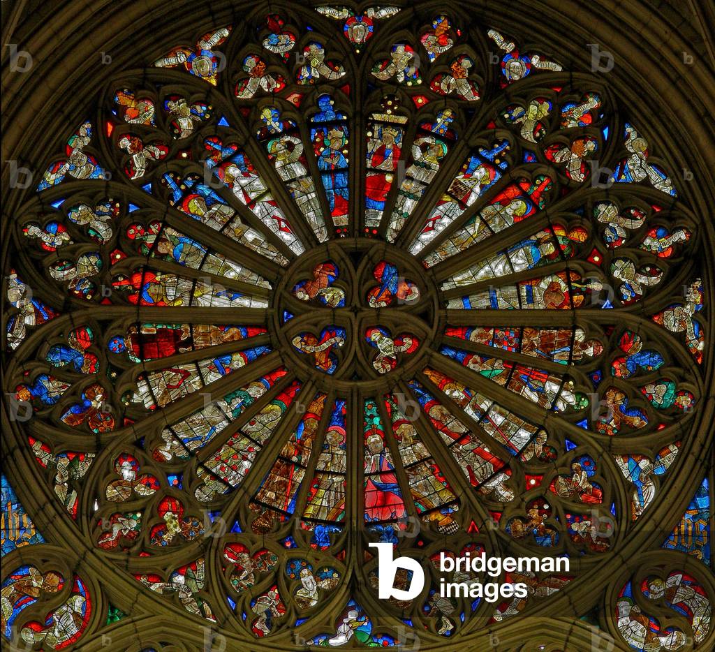 Window w217, the north rose window, depicting the Coronation of the Virgin in the two uppermost openings, surrounded by angels carrying musical instruments and the Instruments of the Passion (rose window - internal)