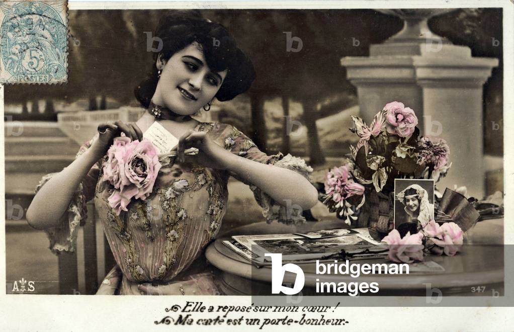 Young woman in love writing to the young man about her thoughts. “” It rests on my heart, my card is a lucky charm!” Postcard beginning 20th century (1906)
