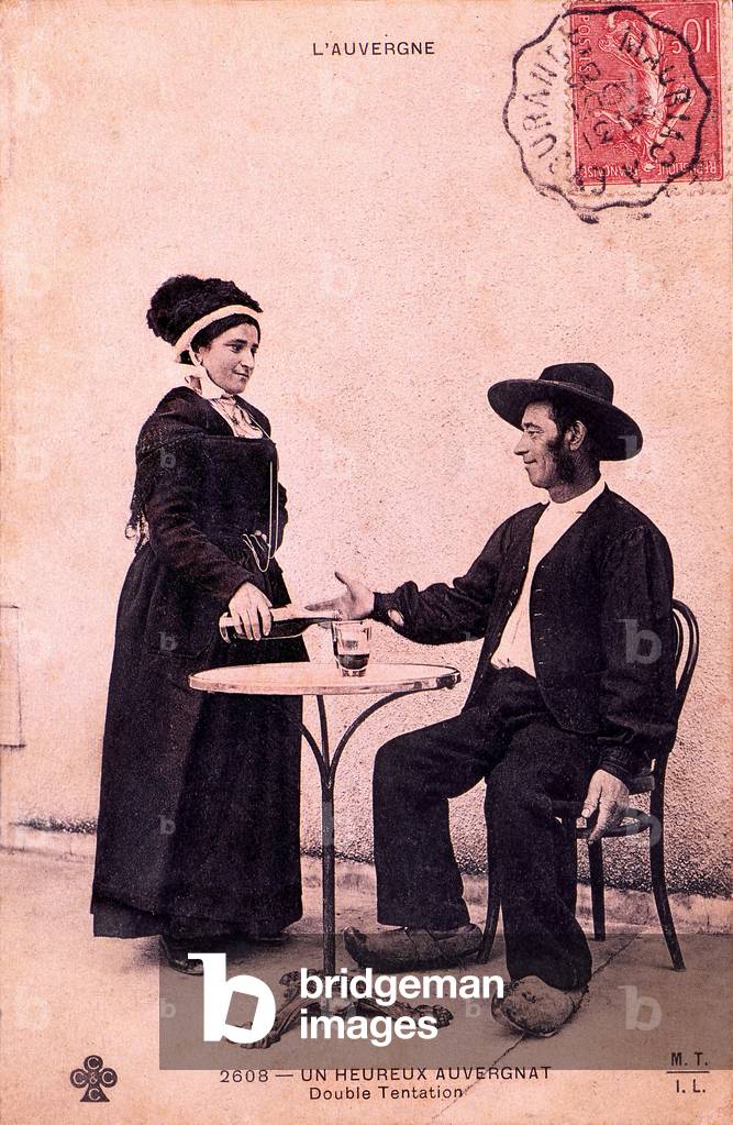 Alcohol and folklore. Double temptation of a “happy Auvergnat”: a glass of red wine served by a pretty girl! Postcard beginning 20th century.