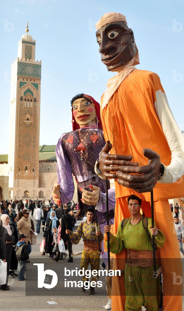 Giant puppets in front of the minaret of the Hassan II Mosque in Casablanca, Morocco - With its 201 meters, this minaret is the highest in the world - Islam - Minaret of the Hassan II Mosque, Casablanca, Morocco - Photography Patrice Cartier 23/02/2014 -