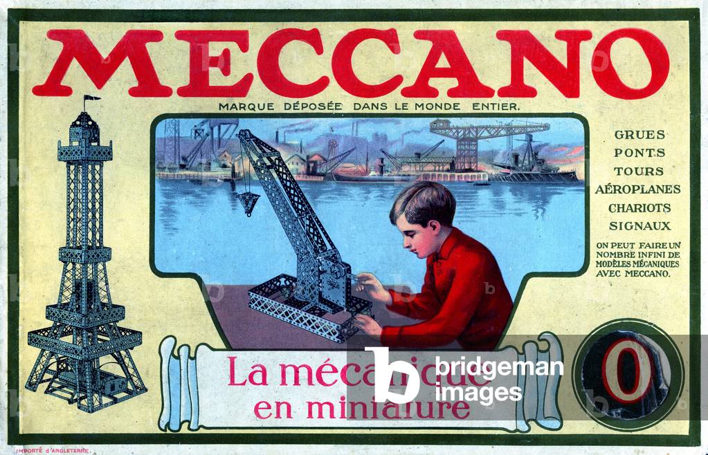 Lid of an old mechanical construction game box of the brand Meccano - reproduction of the Eiffel Tower with metal pieces - a young boy builds a port crane - games, toy, miniature, model -