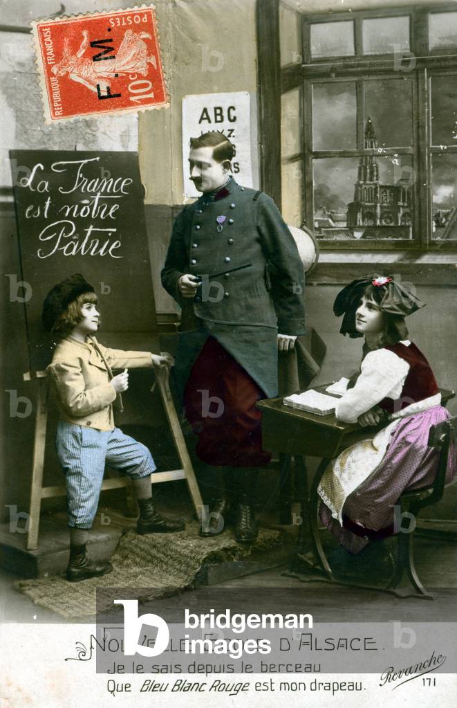 WWI postcard, a poilu soldier being the schoolmaster in Alsace returned to the homeland of France. “I know from the cradle, that blue white red is my flag.