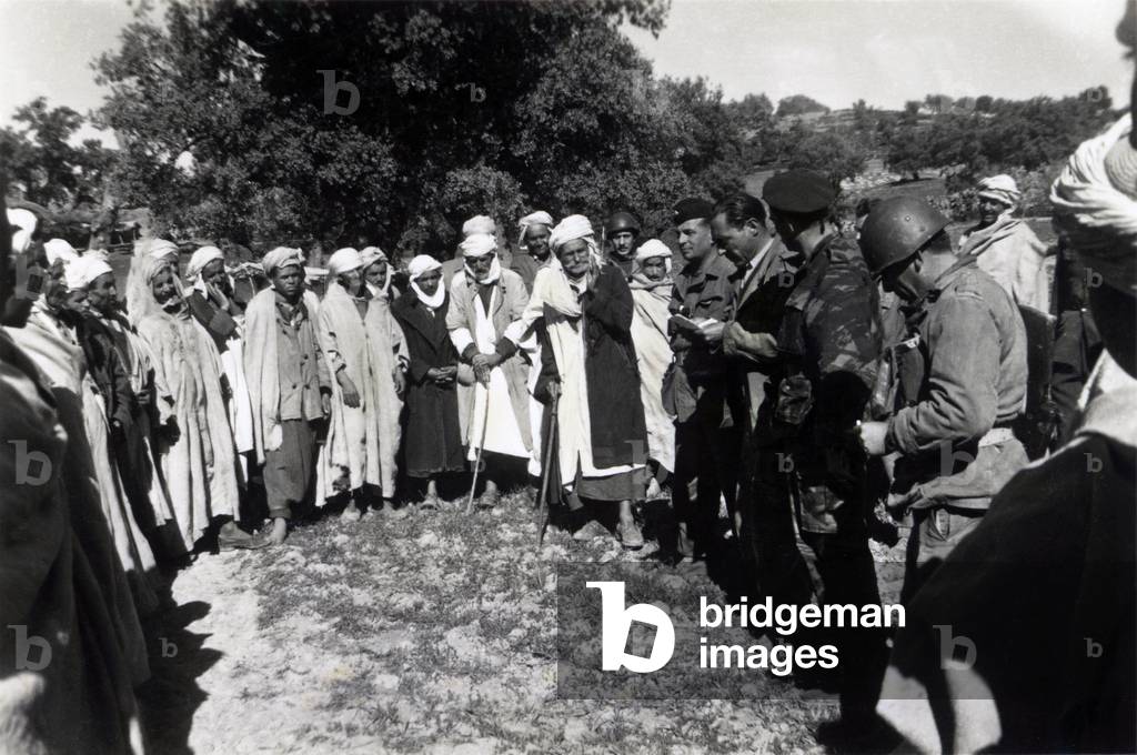 War of Algeria: French soldiers in uniform conducting the interrogation of a group of Algerian villagers (photo)