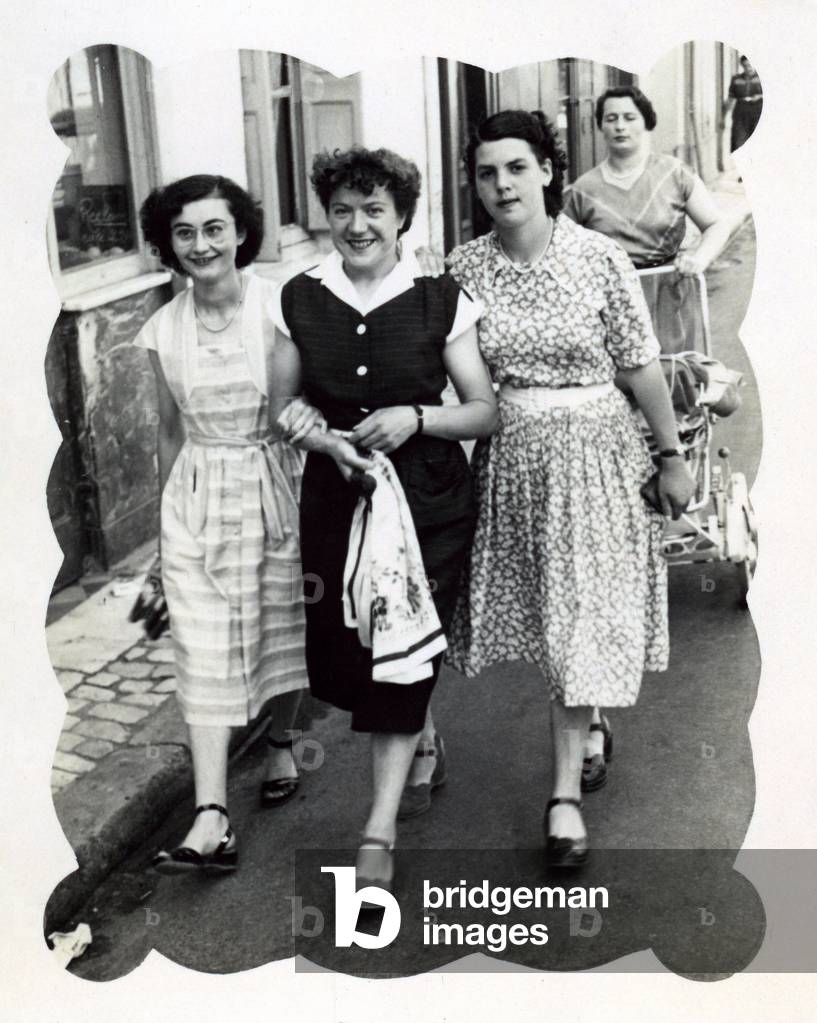 three friends, young women walking down the street holding themselves by their arms, c.1950 (b/w photo)