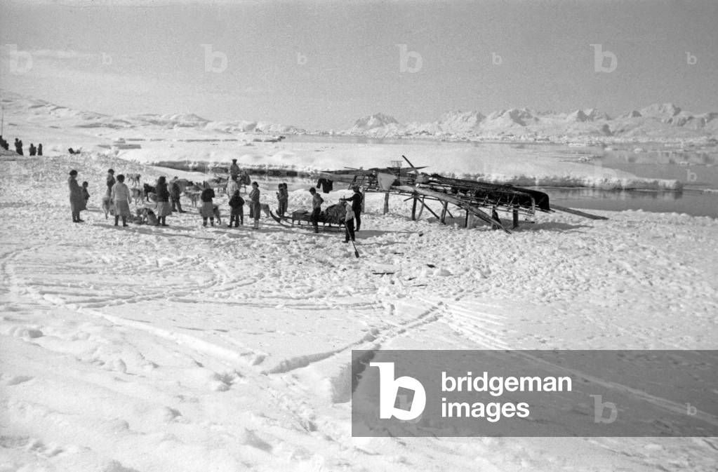 Inuit family, during polar expedition in Greenland, Kangerdlugssuatsiak, Autumn, 1936 (b/w photo)