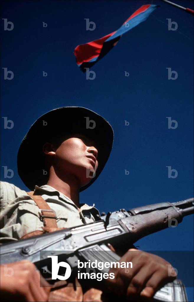 Vietnam: NLF (Viet Cong) soldier and flag at a prisoner exchange, c. 1968