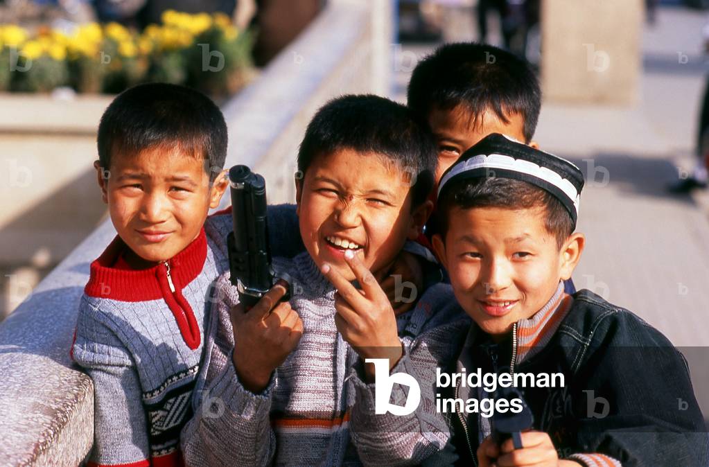 China: Uighur boys with their toy guns, Kuqa, Xinjiang Province