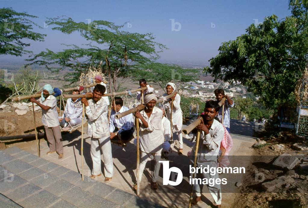 India: Pilgrims being carried in sedan chairs up to the holy Jain Palitana temples (11th to 16th Century CE) in the Shatrunjaya Hills, Gujarat (2004)