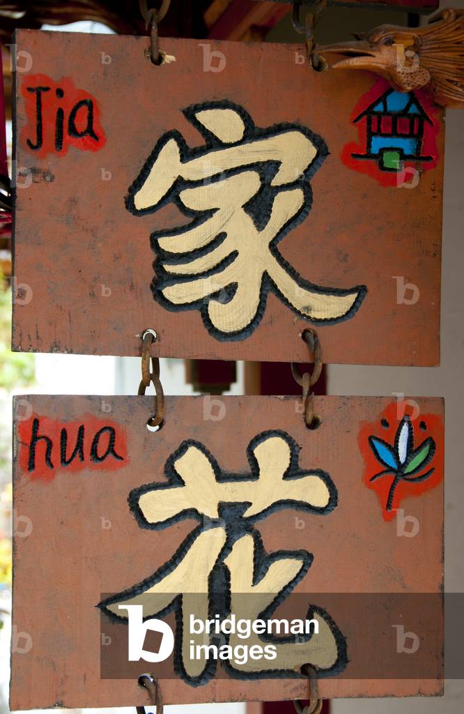 China: Sign displaying both Naxi (Dongba) and Chinese script, Lijiang Old Town, Yunnan Province