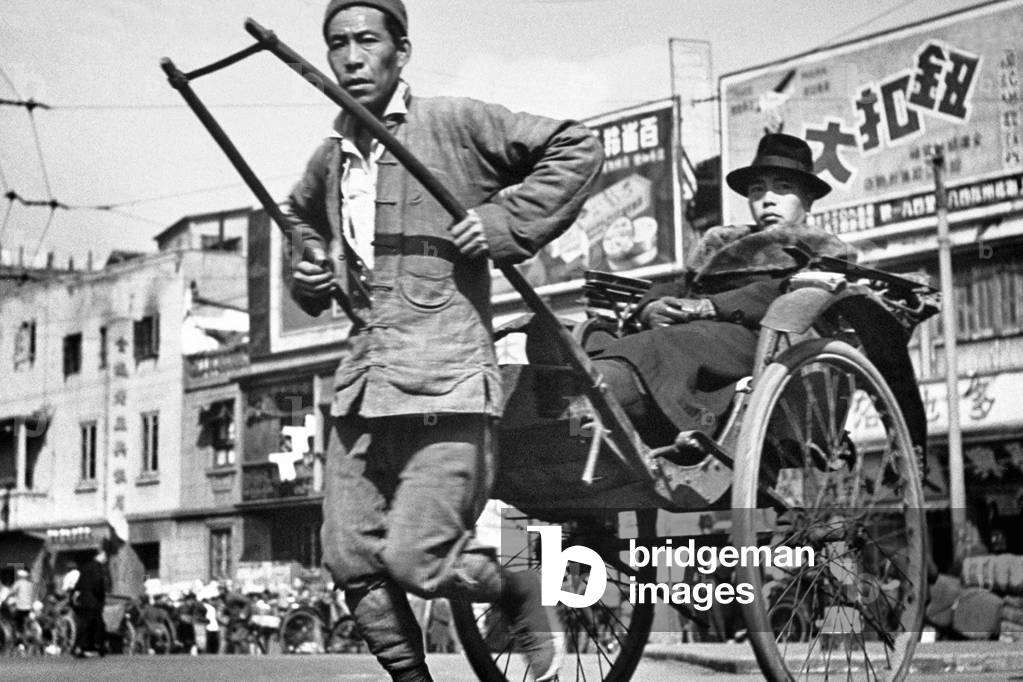 China: Rickshaw puller with well-to-do client, Shanghai, 1947