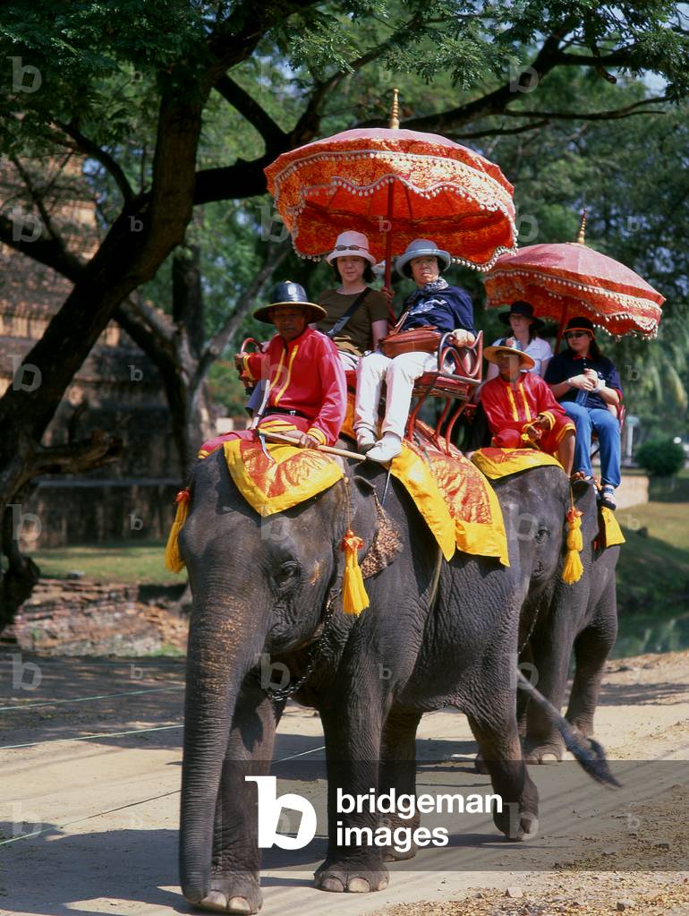 Thailand: Tourists on elephants in Ayutthaya Historical Park