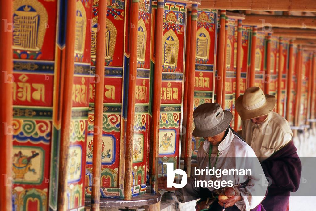 China: Pilgrims circumambulate the monastery while spinning the prayer wheels, Labrang Monastery, Xiahe, Gansu province