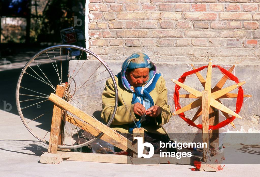 China: A Uighur woman winding silk thread, Atlas Silk Workshop (Atlas Karakhana) in Jiya Village, about 13km northeast of Khotan, Xinjiang Province